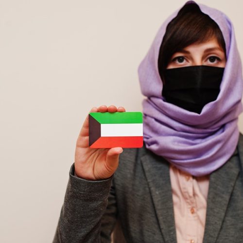 portrait-young-muslim-woman-wearing-formal-wear-protect-face-mask-hijab-head-scarf-hold-kuwait-flag-card-against-isolated-background-coronavirus-country-concept